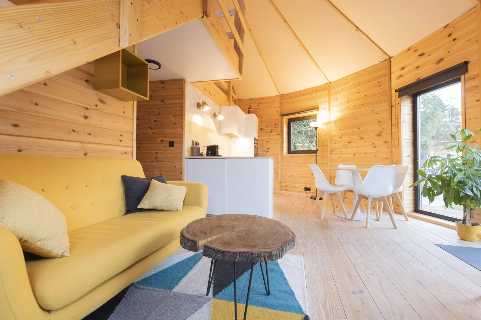 Salon cosy et cuisine équipée à l'intérieur de la yourte